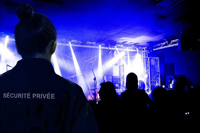 Silhouettes of concert crowd in front of bright stage lights, sm