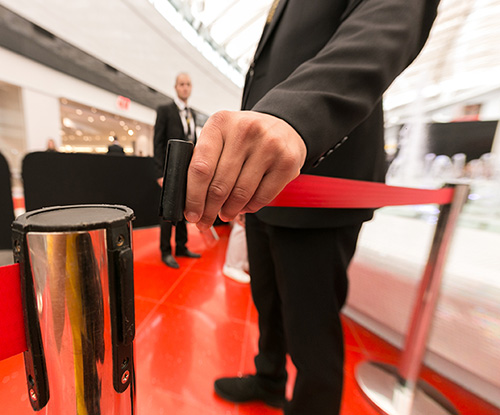 Security hand fastens a red tape closing the passage